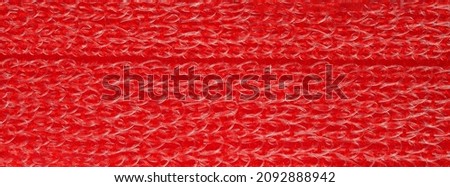 closeup, background, texture, large long horizontal banner. heterogeneous surface structure bright saturated red sponge for washing dishes, kitchen, bath. full depth of field. high resolution photo