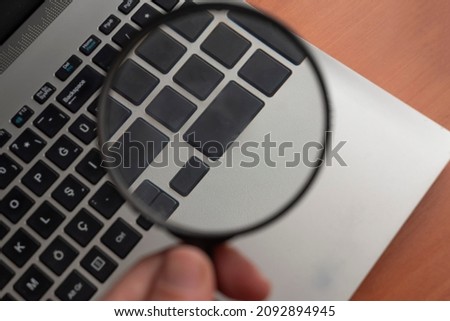 keyboard keys visible through a magnifying glass.
search concept.