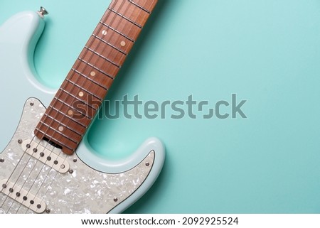 Electric guitar on green table background, flat lay, music instrument concept