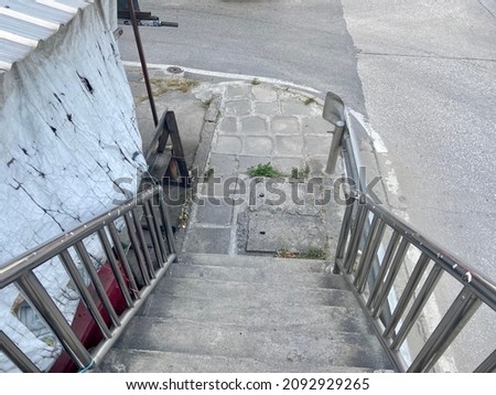The stairs leading down the overpass.  Stainless steel handrails.  Safety first by taking the overpass.