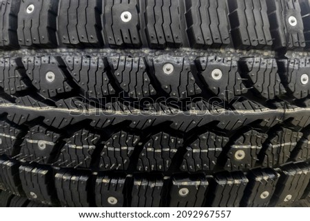 Winter tires for the car. Radial tread, thin slats and metal spikes. Selective focus.