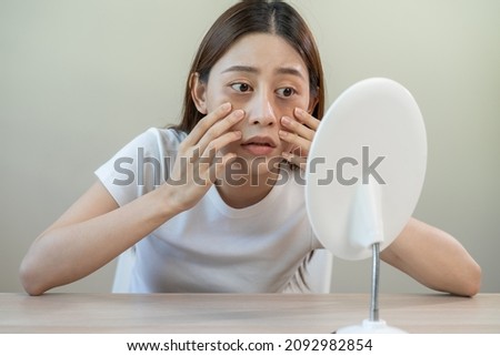 Bored, insomnia asian young woman, girl looking at mirror, without makeup, touch under eyes with problem of dark circles, puffiness, swollen or wrinkles on face. Sleepless, sleepy people, copy space Royalty-Free Stock Photo #2092982854