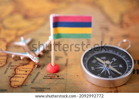 Flag of Mauritius compass and airplane on the world map. The concept of tourism and travel.