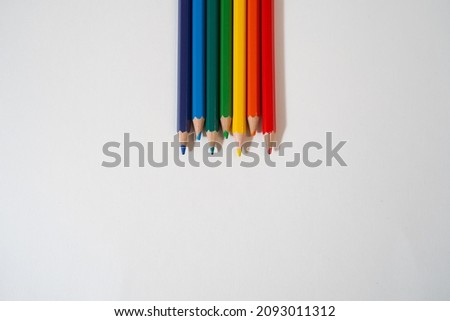 Colored rainbow pencils lie on a white background