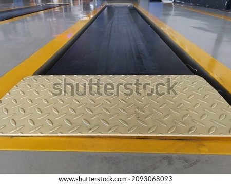Checker plate steel at vehicle inspection service center background.