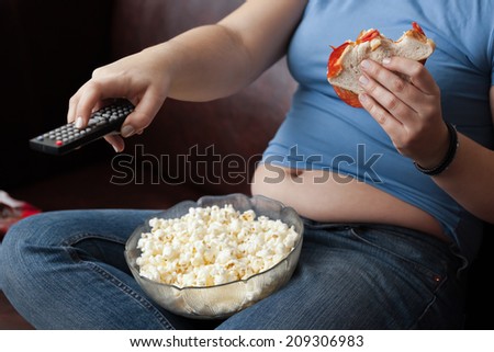 Woman snacking and zapping. Royalty-Free Stock Photo #209306983