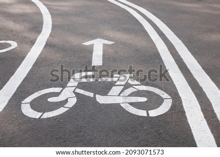 Bicycle lane with sign and arrow pointing direction on asphalt