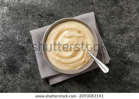 Bowl with delicious semolina pudding on grey table, top view Royalty-Free Stock Photo #2093083141