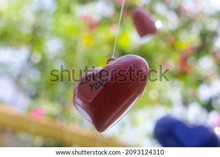 Closeup of a pink heart shape with "love you" text in the love garden