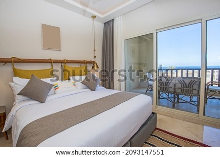 Interior design decor furnishing of luxury show home bedroom showing furniture double bed with balcony terrace and sea view