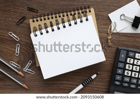 two notebooks with a spring on a wooden background with a pencil calculator pen business concept. Office concept. View from above.