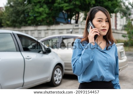 Woman drivers call insurance after a car accident before taking pictures and sending insurance. Online car accident insurance claim idea after submitting photos and evidence to an insurance company.