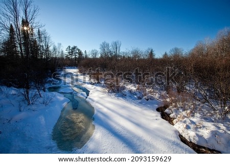 Frozen stream running through a Wisconsin forest, horizontal