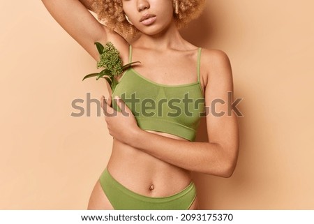 Cropped shot of faceless healthy woman with perfect body demonstrates results of slimming dressed in green underwear has slim shapes smooth skin. Wellness organic cosmetics and spa treatment concept