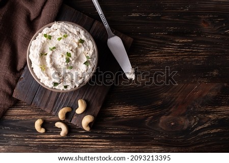 Vegan cream cheese made from nuts, fermented cashews and microgreens on dark wooden background, copy space. Royalty-Free Stock Photo #2093213395