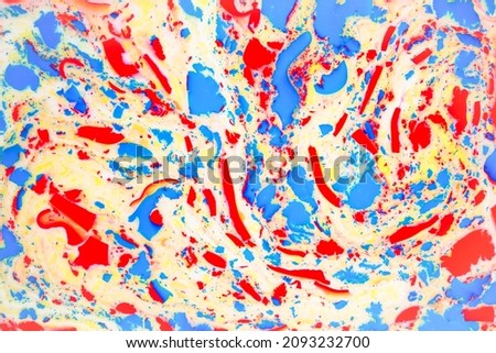 Variegated colored background, paint particles on white. Dye stains on the surface of the liquid. Abstract background.