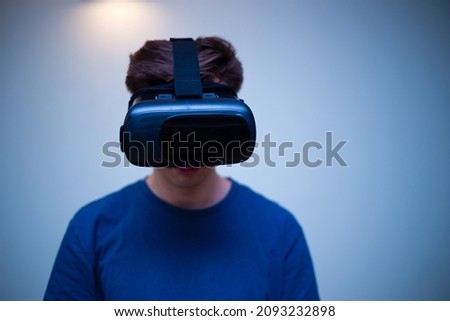 An excited young guy in virtual reality glasses is immersed in the metaverse