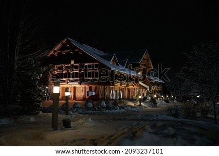 Illuminated wooden house with garlands in winter