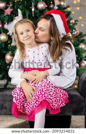 Beautiful woman together with her daughter at christmas