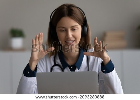 Telemedicine. Young woman doctor in earphones talk explain diagnosis to patient using conference app on laptop give recommendation prescription. Millennial doc in headset counsel client remotely on pc