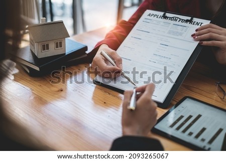 Close up of Business woman or agent pointing and signing agreement for buying house. Bank manager concept.