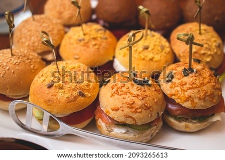 Burger mini burgers snacks on a wooden table with craft paper, beautifully decorated catering banquet table on corporate christmas birthday party event wedding celebration

