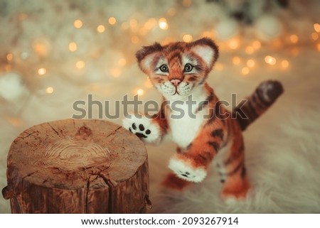 The Year of the tiger. Symbol of the year. A tiger figurine made with your own hands. Children's toy tiger. Tiger in winter. The year is 2022.