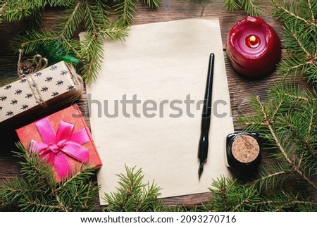 Blank paper page with copy space, quill pen, burning candle and fir tree branches on the wooden table background. New year plans template. Letter to the Santa Claus concept.