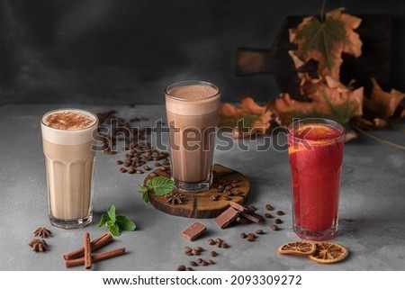 still life autumn composition with many transparent glasses of refreshing drink, raf coffee and espresso with frothed milk on a dark gray background. template for drink menu of cafe and restaurant