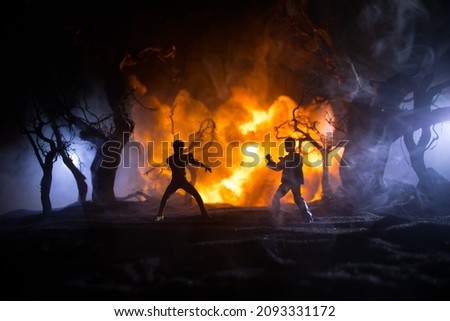 Karate athletes night fighting scene at burning forest. Character karate. Posing figure artwork decoration. Sport concept. Decorated foggy background with light. Selective focus Royalty-Free Stock Photo #2093331172