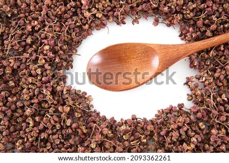 Dried peppercorns and wooden spoon