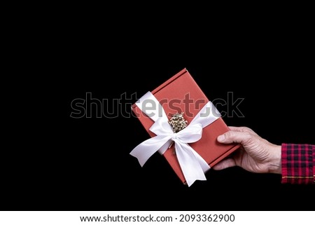 A man giving a red gift box.