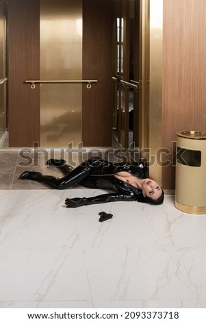 Hit woman. Woman in a latex suit killed in gunfire shot in the chest

 Royalty-Free Stock Photo #2093373718
