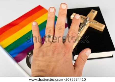 Picture of a bible, cross and a rainbow flag