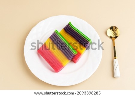Kue Lapis or Kue Pepe or Rainbow sticky layer cake, Indonesian traditional dessert made from rice flour and coconut milk, steamed layer by layer. Served in white plate, copy space. 
