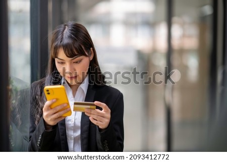 Businesswoman holding credit card while using laptop computer to buy or pay online, online shopping.