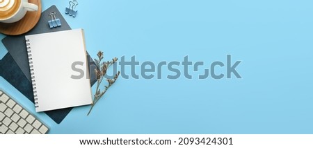 Flat lay, Minimal work space - Creative flat lay photo of workspace desk. Top view office desk with laptop, notebooks and coffee cup on blue color background.  Royalty-Free Stock Photo #2093424301