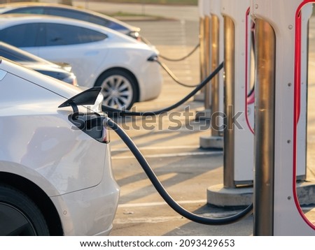 Electric cars charging at charging station outdoors at sunset. Royalty-Free Stock Photo #2093429653