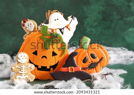 Tasty cookies for Halloween celebration on color background