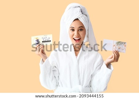 Young African-American woman with gift certificates for massage on color background