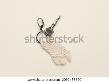 Key with handmade cotton keychain on light background