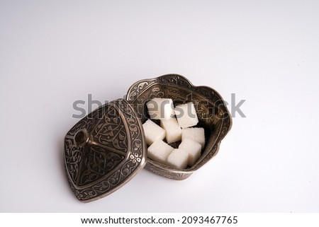 Sugar in a silver traditional bowl on white background 