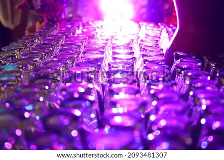Defocused blurred abstract background with colorful light with colorful glasses on top that are neatly arranged