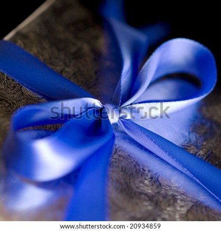 Blue Ribbon Tied in a Bow on Silver Gift.  High Resolution Image Shot with Macro Lens.  Carefully Spotted and Retouched.