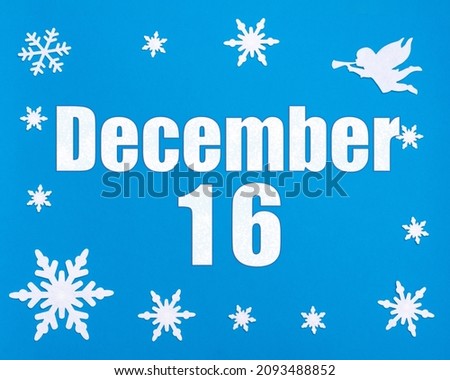 December 16th. Winter blue background with snowflakes, angel and a calendar date. Day 16 of month. Winter month, day of the year concept.