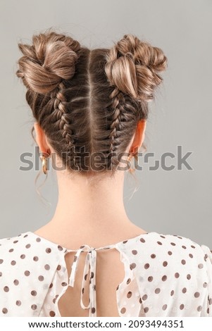 Beautiful young woman with braided hair on grey background Royalty-Free Stock Photo #2093494351