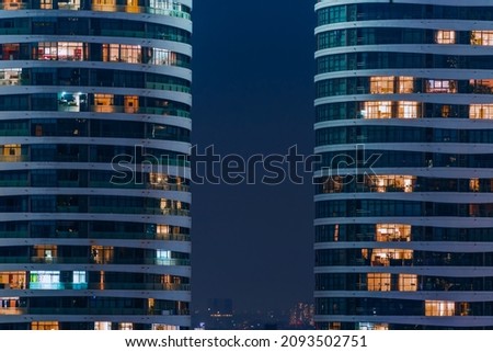 Glass facade of modern city high rise, buildings show lighting using by human activity, energy usage at night time. Glowing windows of skyscrapers at night. Location Ho Chi Minh city, Vietnam. Royalty-Free Stock Photo #2093502751