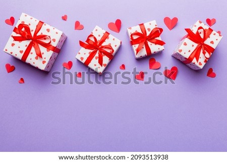 Valentine day composition: red gift box with bow and heart. Christmas present. View from above. Space for text. Holday greeting card.