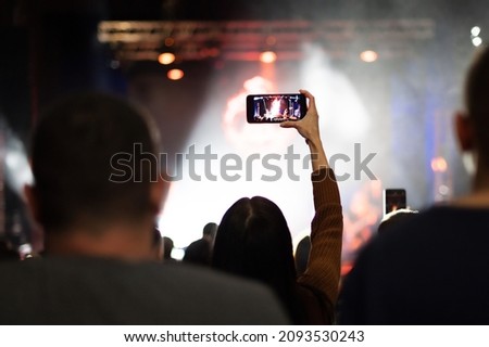 young girl takes a rock music concert on the phone. Nightlife at the festival