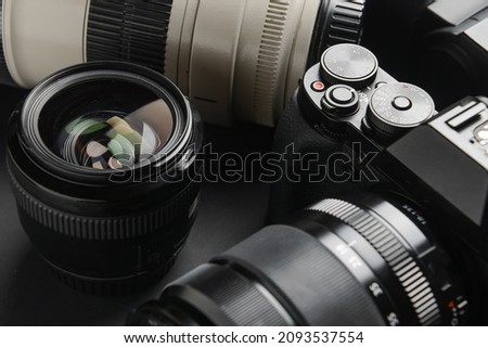 Digital camera and lenses on dark background, closeup